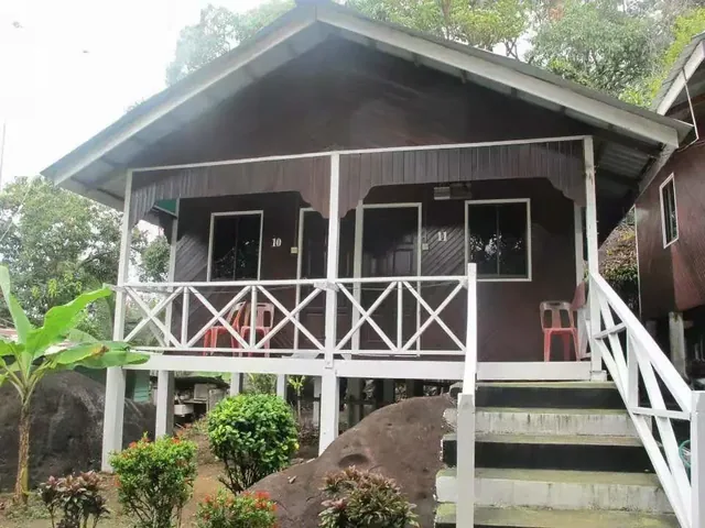 Aguna 度假村的木质小屋、白色栏杆阳台与热带植物