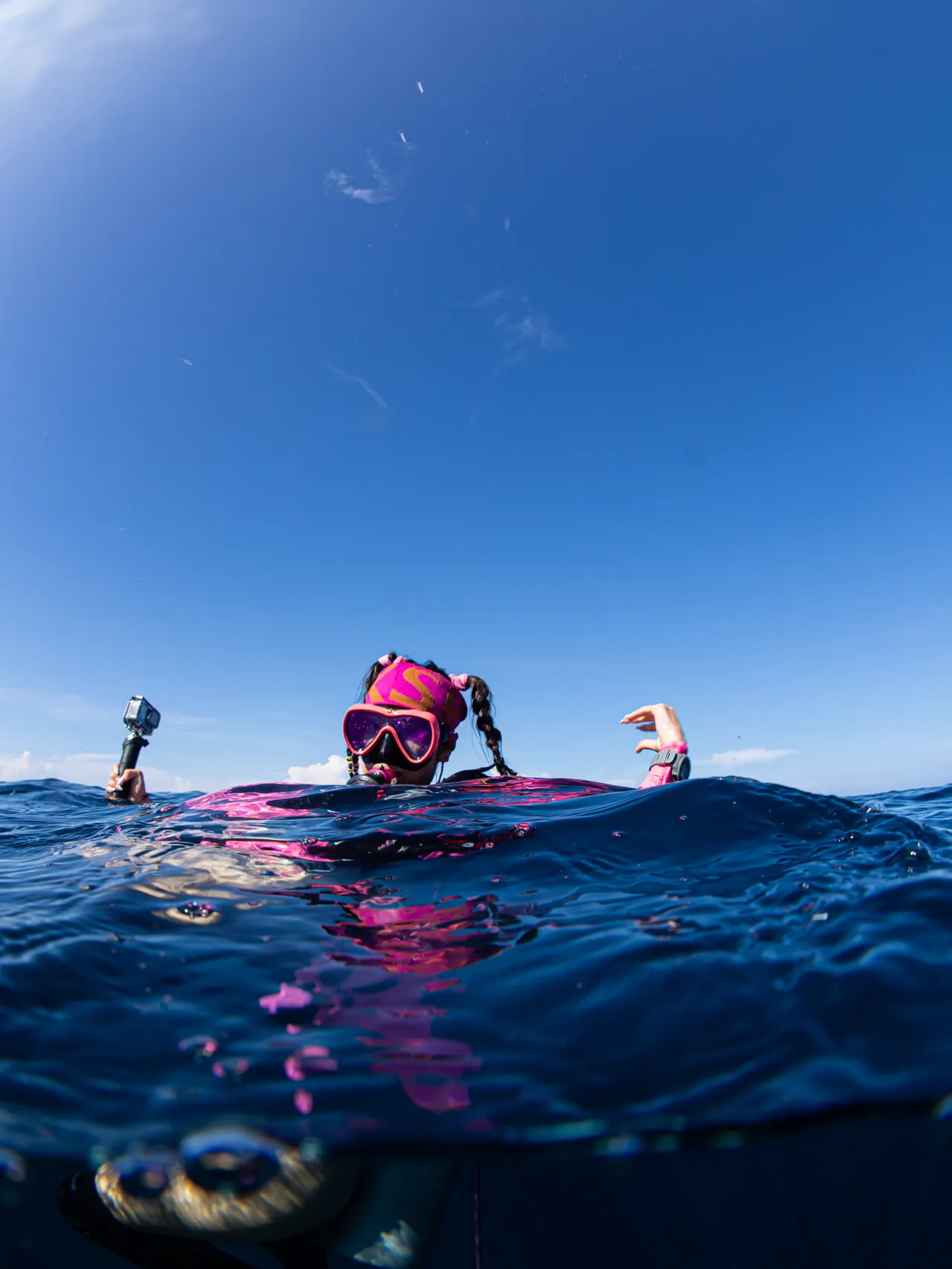 A scuba diver at the sea surface beneath a blue sky